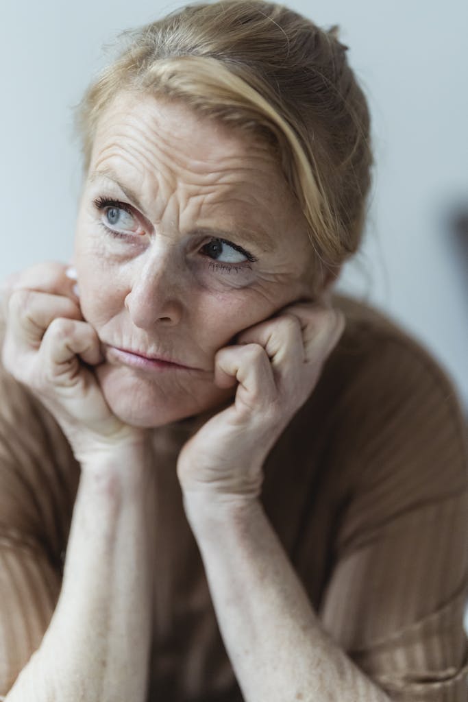 Portrait of an elderly woman in deep thought, expressing emotions and contemplation.